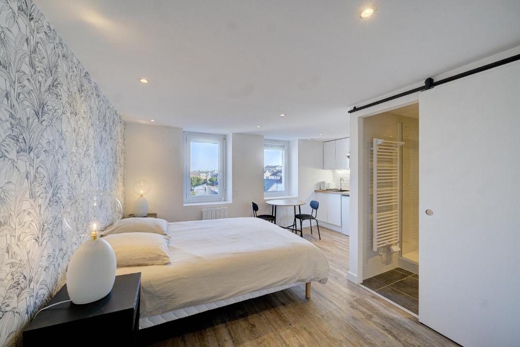 圣纳泽尔L'Espadon - Appart'Escale的一间带大床的卧室和一间厨房