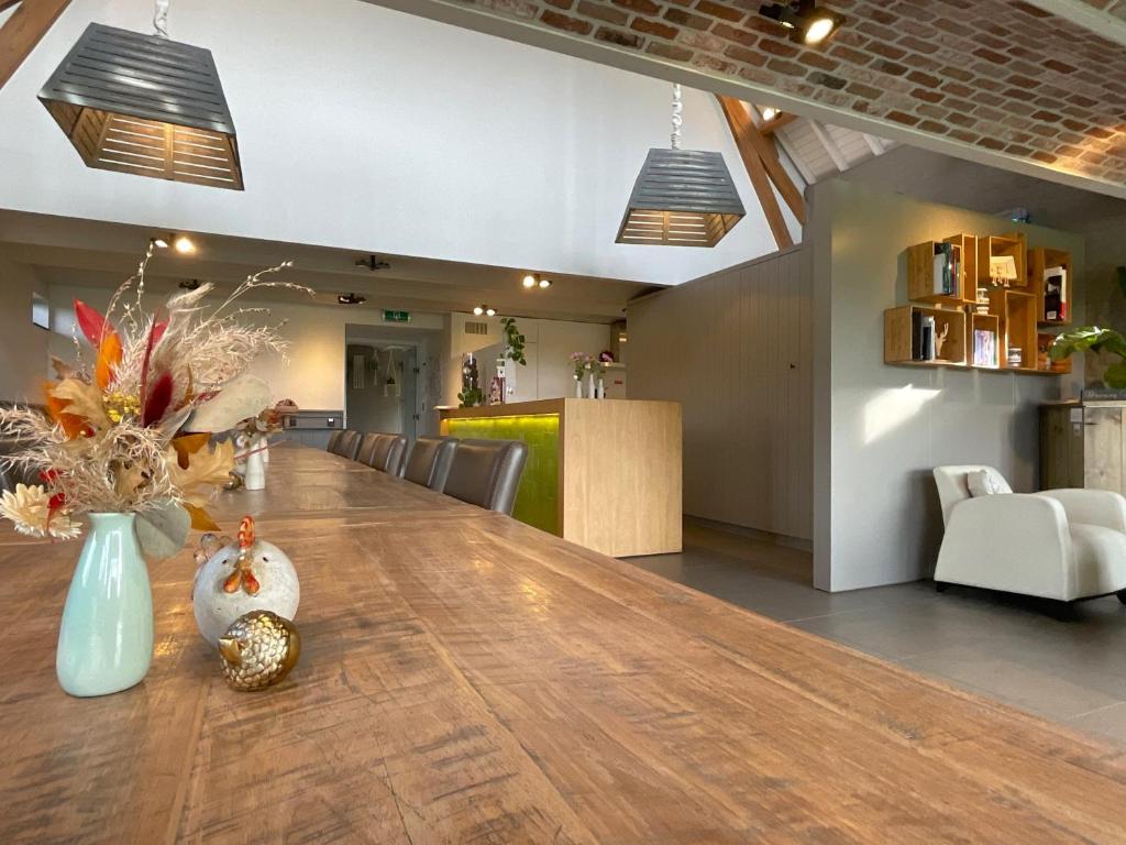 ZwevegemHotel - B&B PassaDia的大型用餐室设有一张大木桌
