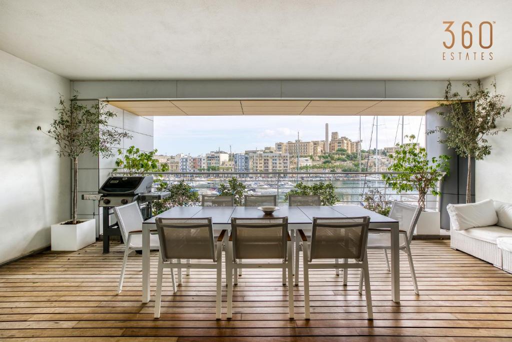 Taʼ XbiexElegant, spacious LUX home with Mesmerising Views by 360 Estates的一间带桌椅和大窗户的用餐室