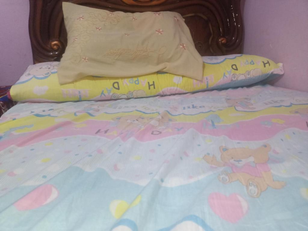 十月六日城HOSTEL的一张带泰迪熊和枕头的儿童床