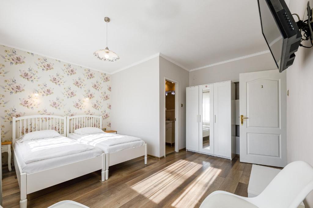阿拉德贝拉酒店的一间卧室配有2张白色的床和花卉壁纸