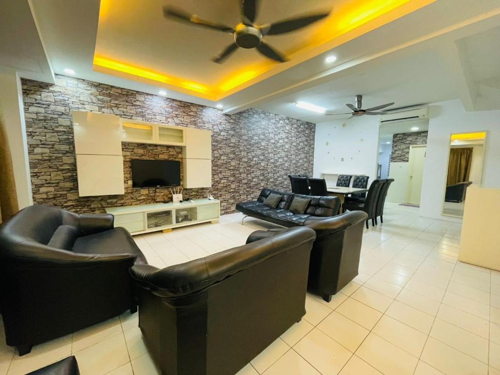 万挠FREE Wi-fi 100mbps I Emerald Cove Rawang的客厅配有皮革家具和石墙
