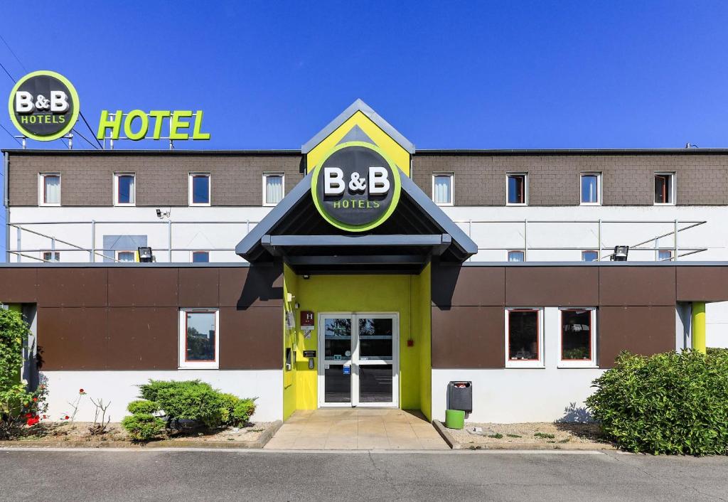 第戎B&B HOTEL Dijon Nord Zénith的前面有标志的酒店