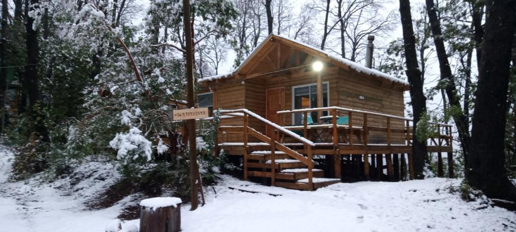 RecintoCabañas el Mirador的雪中树林里的小木屋