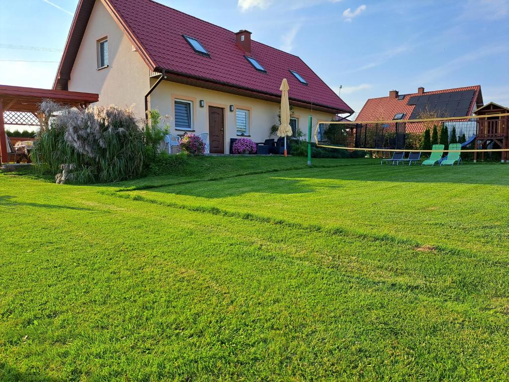 ZakliczynGazdówka的一座带绿色草坪的庭院