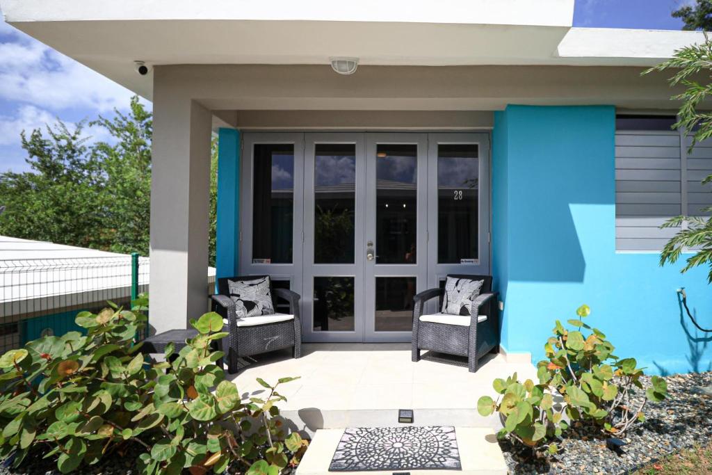 卡沃罗霍Casa Arrecife 28的蓝色房子,在庭院里配有两把椅子