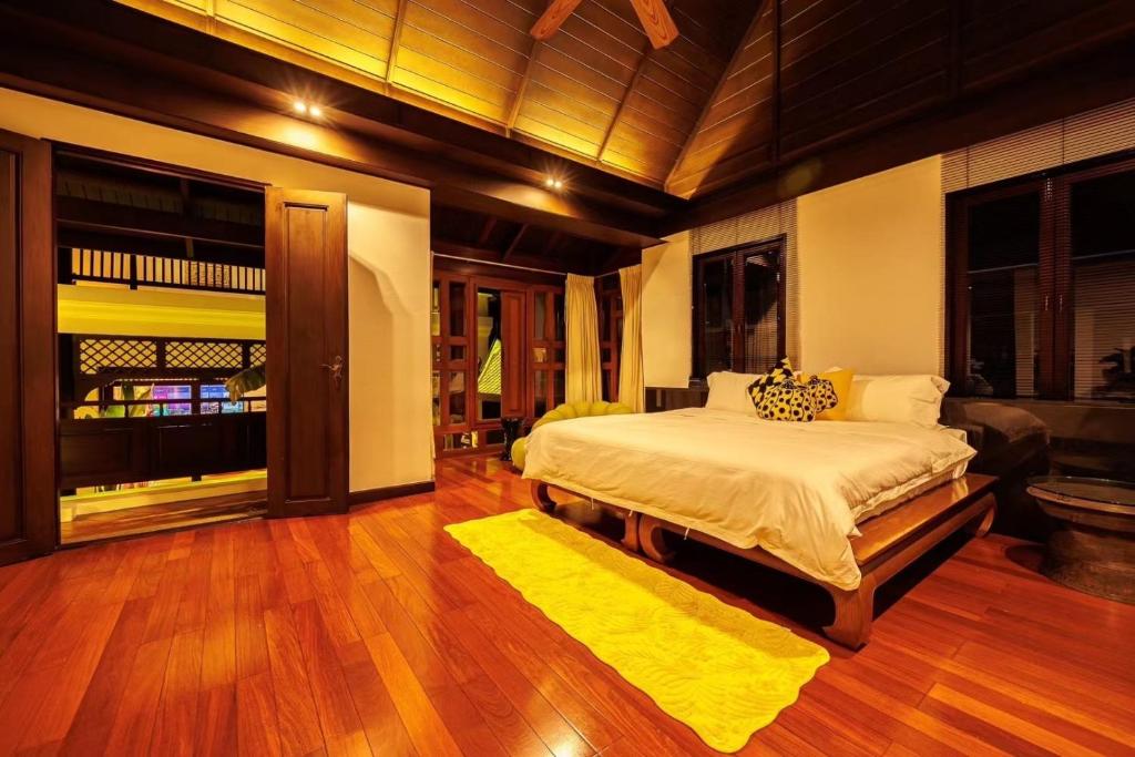 曼谷夏日马卡龙系列 四卧三卫 私人泳池的一间卧室配有一张大床和黄色地毯。