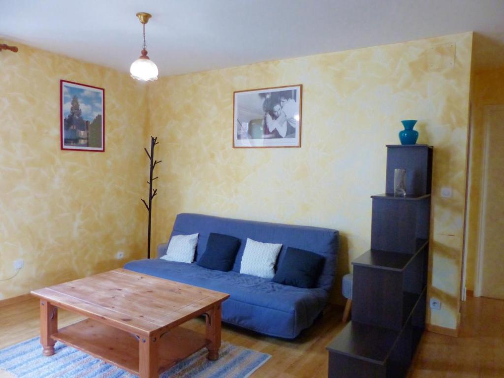 Saint-PalaisAppartement Saint-Palais (Allier), 3 pièces, 6 personnes - FR-1-489-418的客厅配有蓝色的沙发和桌子