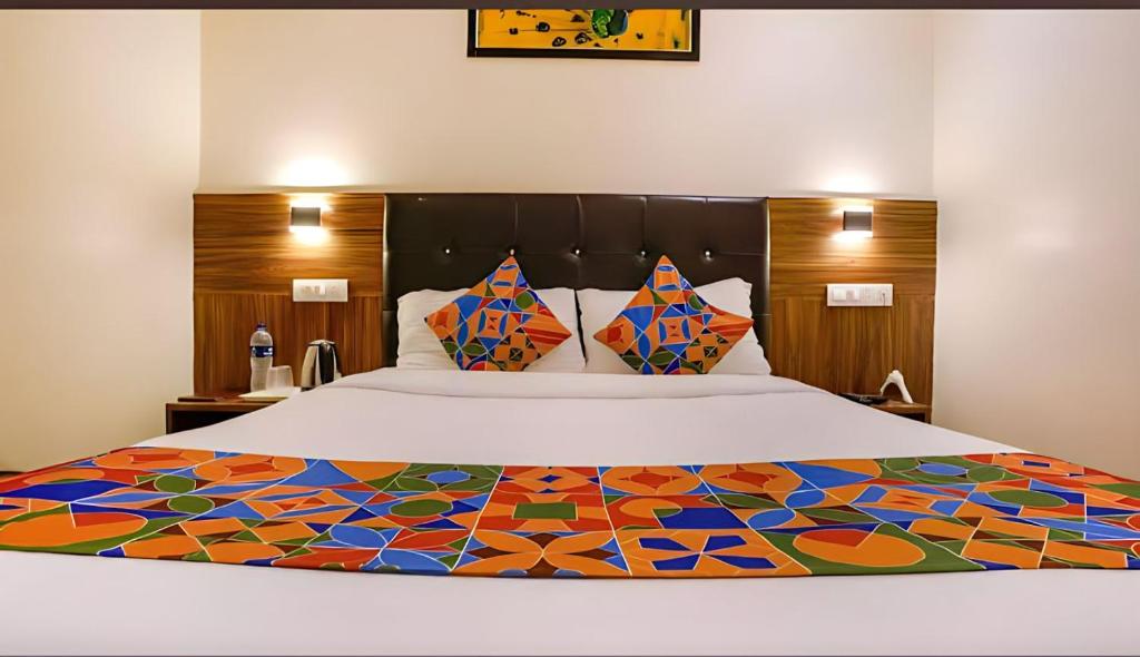 孟买Hotel Deluxe Residency的一间卧室配有一张大床和彩色床罩
