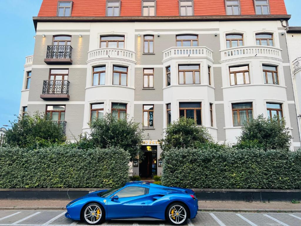 布兰肯贝赫Gatsby Hotel - Adults Only - Small Luxury Hotel - by F-Hotels的停在大楼前的蓝色汽车
