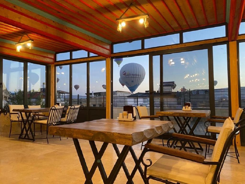 格雷梅Rustic Caves Hotel的一间设有桌椅的餐厅和一个空中热气球