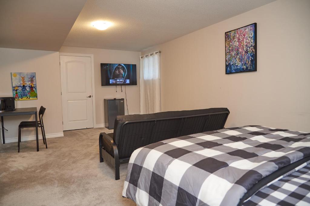 渥太华Fully Furnished En-Suite Basement的一间卧室配有一张床、一张书桌和一台电视