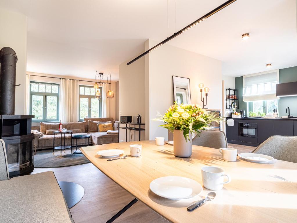 欧巴德伍斯图Ferienhaussiedlung Strandperlen Küstenhof 4b (Typ IX)的厨房以及带木桌的起居室。