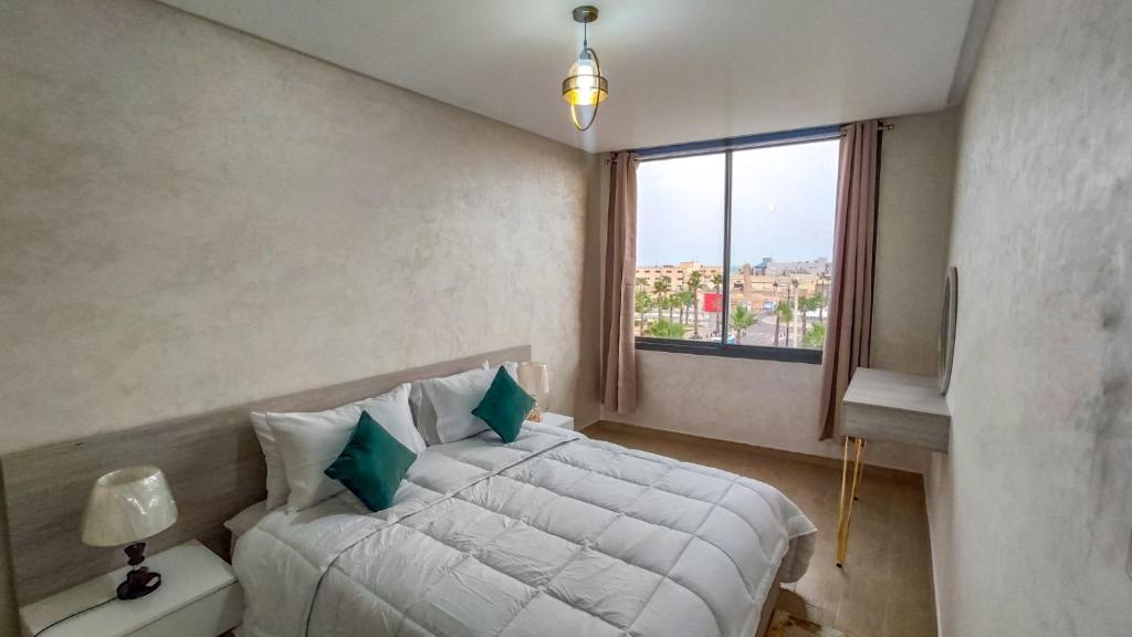 达赫拉Palm D'or-Appartement familial de luxe au centre de Dakhla的卧室配有白色的床和窗户。
