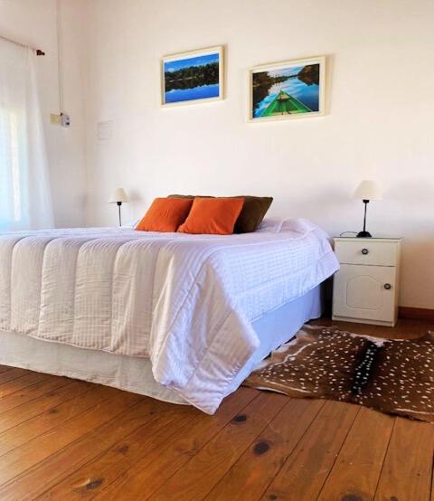 梅赛德斯Duplex Reencuentro的一间卧室配有带白色床单和橙色枕头的床。