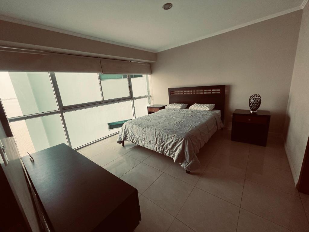 瓜亚基尔Suite frente al río en Puerto Santa Ana Riverfront的一间卧室设有一张床和一个大窗户