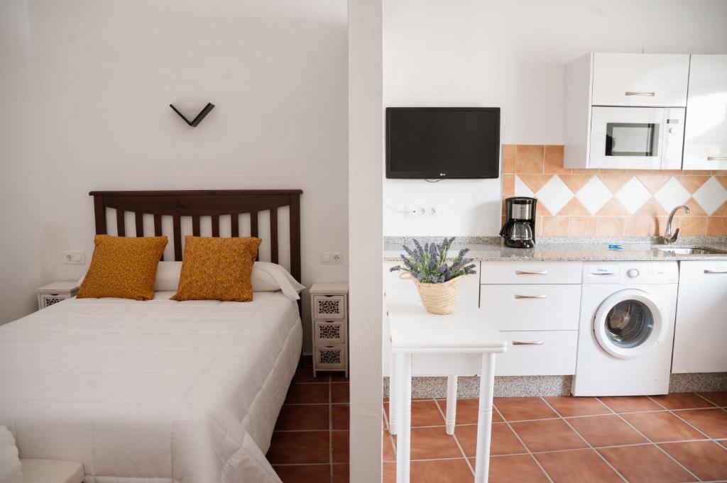 特鲁希略VIVE Trujillo的一间卧室配有一张床,厨房配有洗衣机