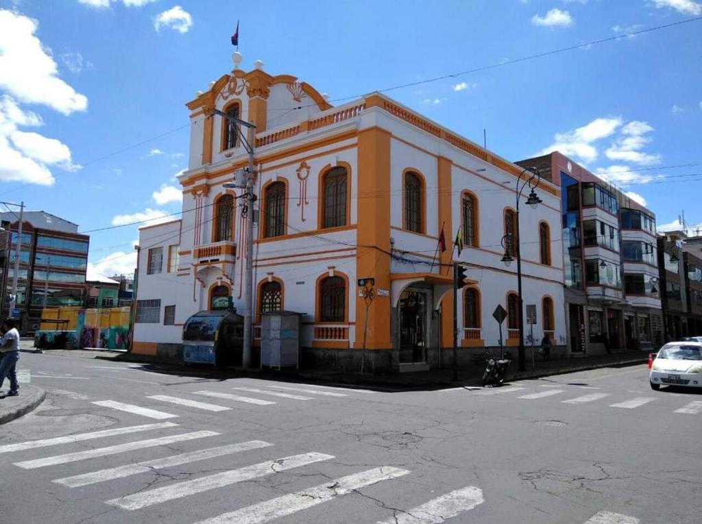 里奥班巴METROPOLITANO HOTEL的街道拐角处的橙色和白色建筑