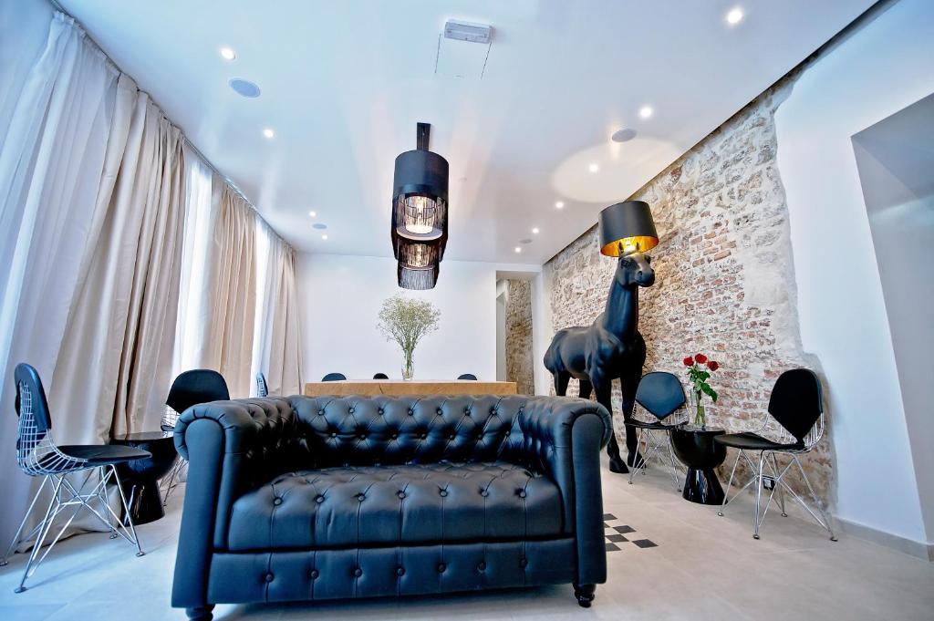 斯普利特木星豪华酒店的客厅设有蓝色的沙发和砖墙