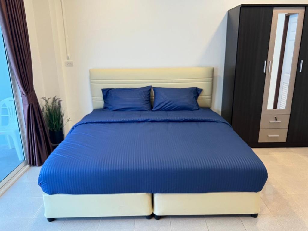 Ban Thung ThongAB House的卧室内的一张带蓝色枕头的床