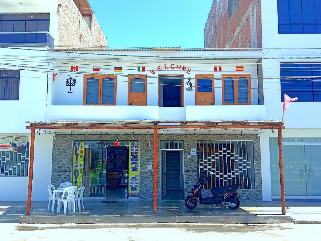 帕拉卡斯HOSPEDAJE JOSUE - paracas的停在前面的一座带摩托车的建筑