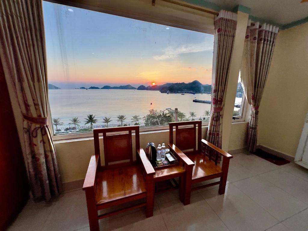 吉婆岛Manh Vuong Hotel的客房设有两把椅子和一个享有美景的大窗户