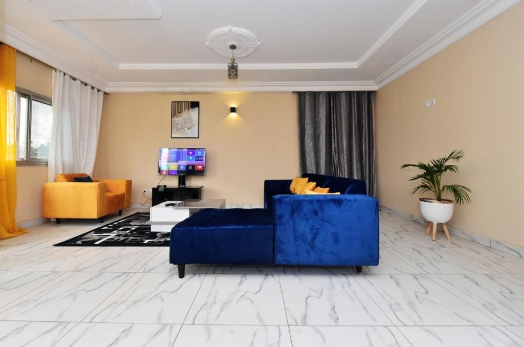 雅温得Appartement meublé, 2 douches, 2 chambres的客厅配有蓝色的沙发和电视