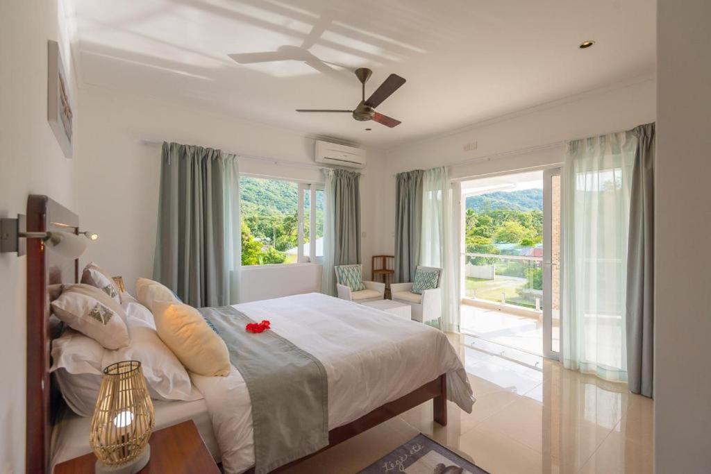 普拉兰大安塞区Tropic Villa Annex的一间卧室配有一张带吊扇的床