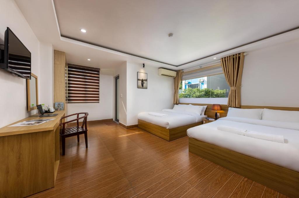吉婆岛Cat Ba Hongkong Hotel的酒店客房配有两张床和一张书桌