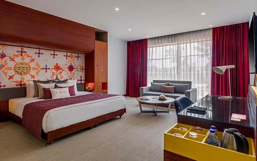 赖布尔Triton By Shyama Hotels & Resorts的酒店客房设有一张大床和一张沙发。