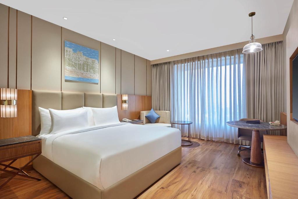 瓦拉纳西Doubletree By Hilton Varanasi的卧室配有一张白色大床和一张书桌