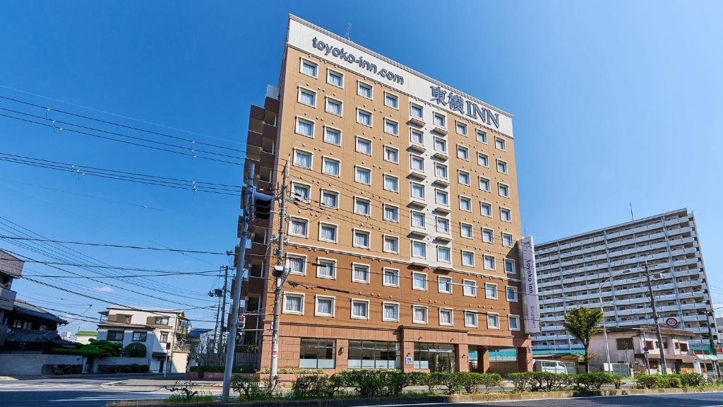 大阪Toyoko Inn Shin-Osaka-eki Higashi-guchi的街道拐角处高大的砖砌建筑