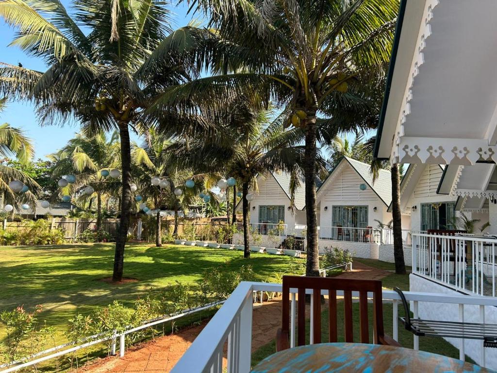莫尔吉姆S2 Beach Cottages的棕榈树房屋的阳台享有风景。