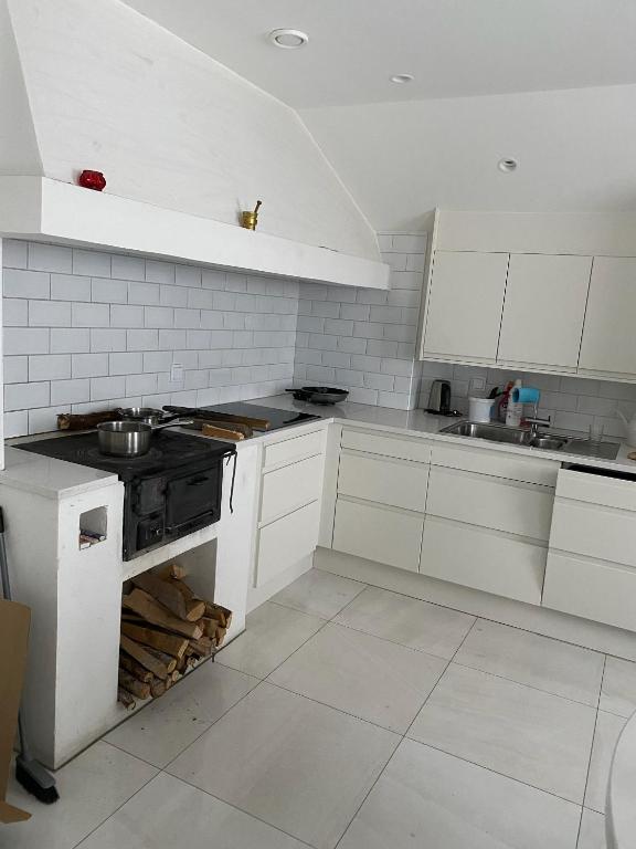 布罗斯Natursköna的厨房配有白色橱柜和炉灶烤箱。