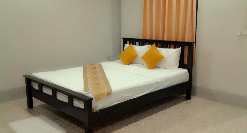Ko PorMSD House的一间卧室配有黄色和白色枕头的床