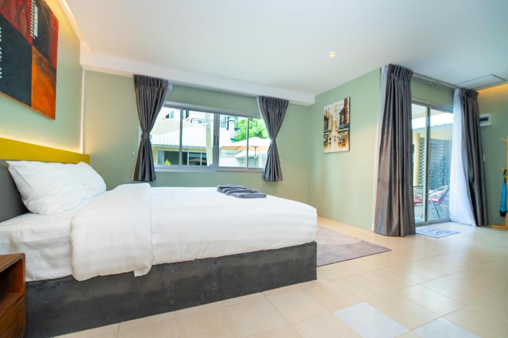 卡塔海滩Maiiam Bungalows Kata Beach的卧室设有白色大床和窗户。