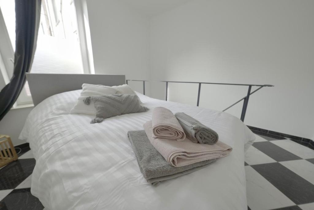 沙勒罗瓦Studio Didine的一张带毛巾和枕头的白色床