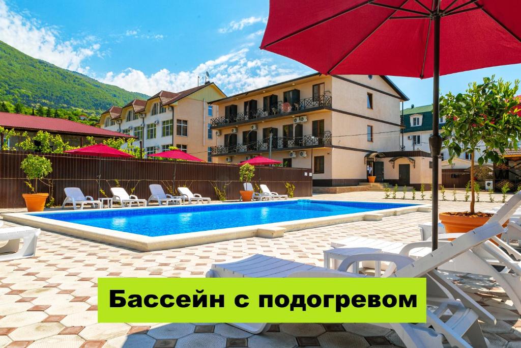 加格拉Отель Taminik的一座带游泳池和红伞的酒店