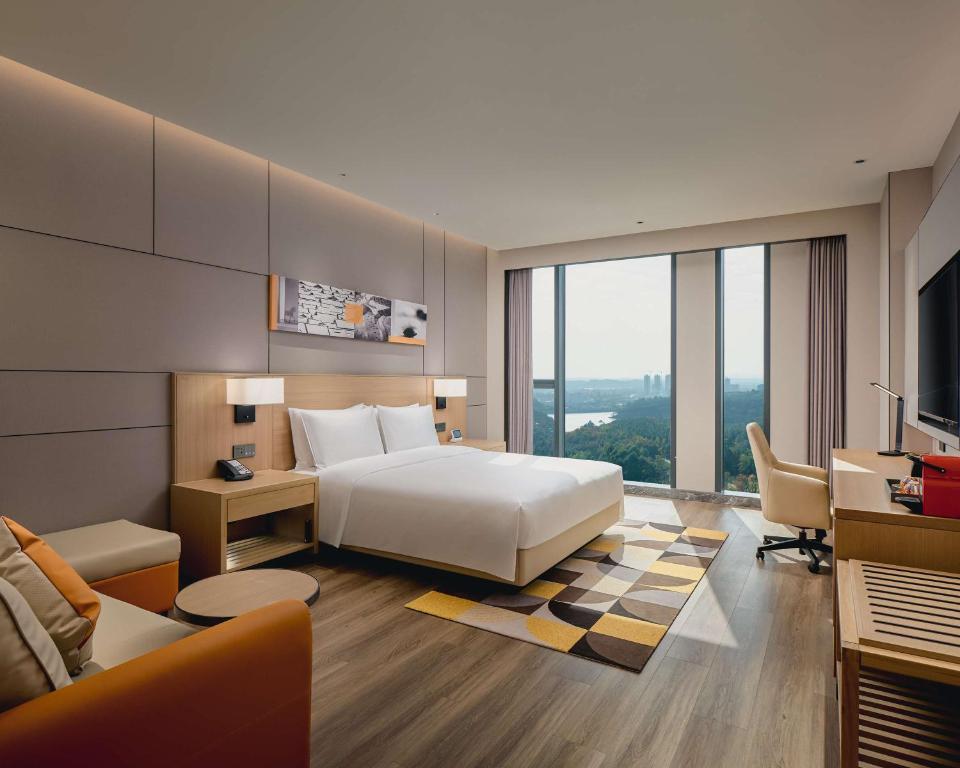 成都成都生物城凯悦嘉轩酒店的酒店客房配有一张床、一张书桌和一张沙发。