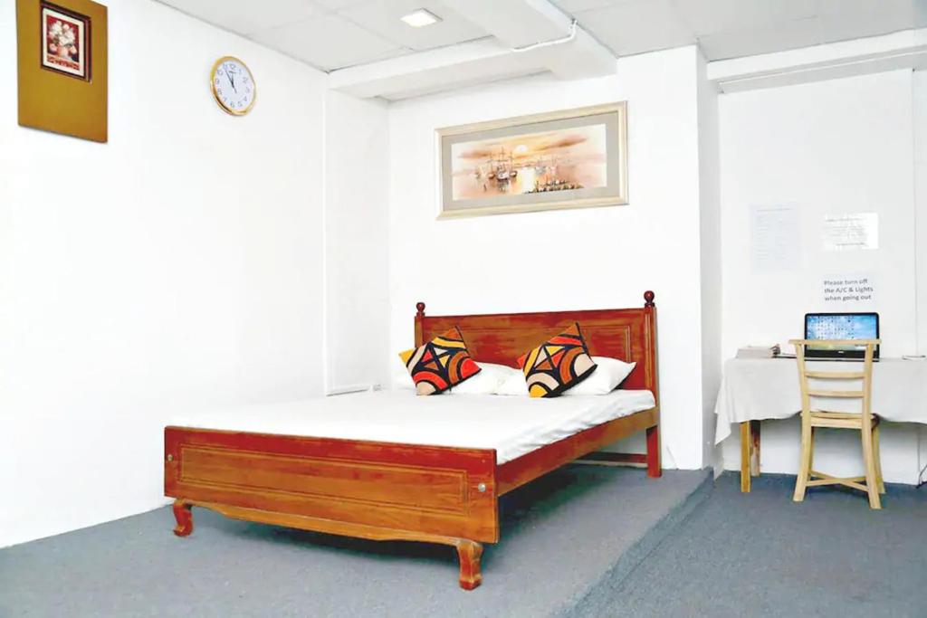科伦坡Beehive Colombo的一张位于带桌子和椅子的房间内的床铺