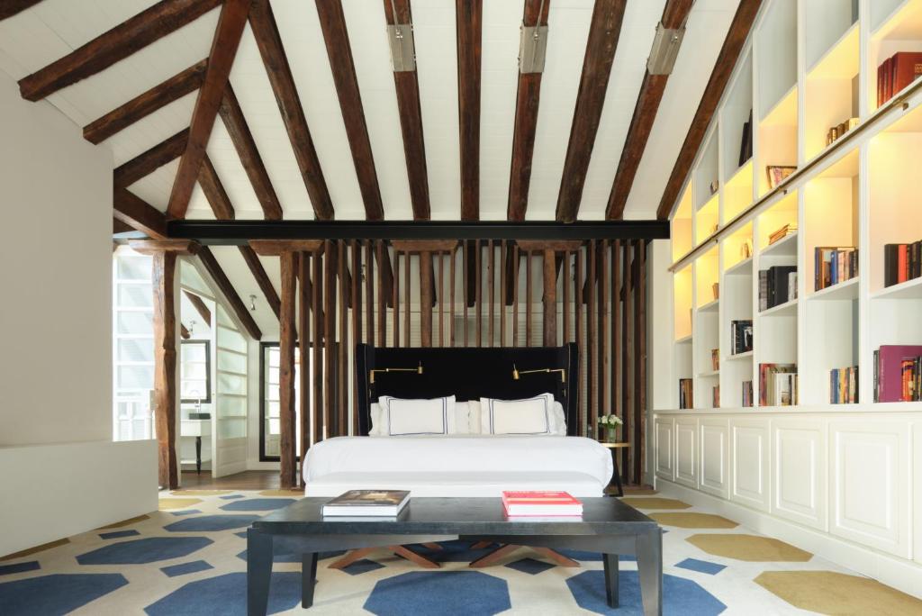 马德里马德里唯一精品酒店的一间卧室配有床、桌子和书架
