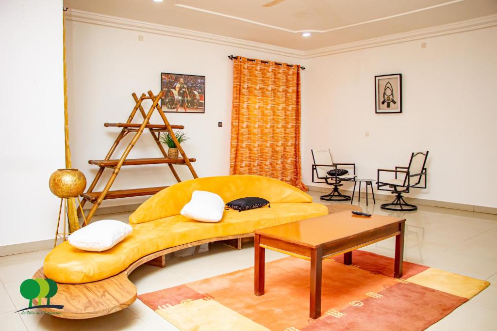 瓦加杜古VILLA DE L'INTEGRATION的客厅配有黄色的沙发和桌子