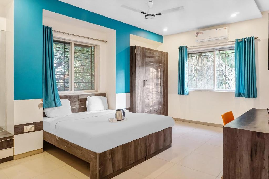 LohogaonSuper Townhouse 749 The Upper Room Near Pune Airport的一间卧室配有一张带蓝色墙壁的大床