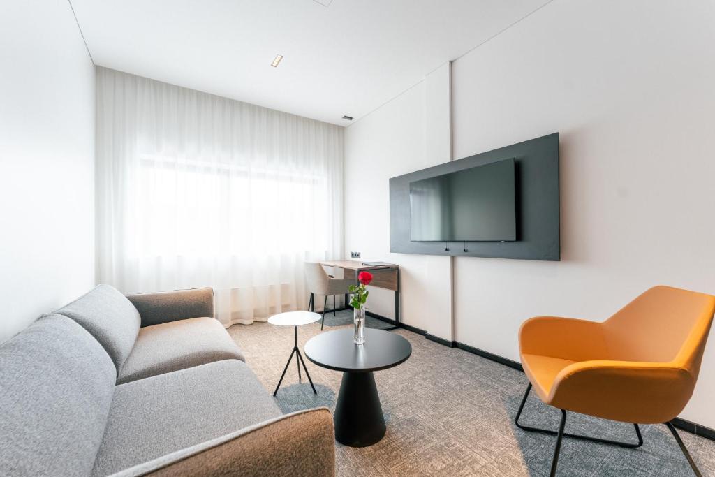 维尔纽斯潘塔德乌什酒店的带沙发和电视的客厅