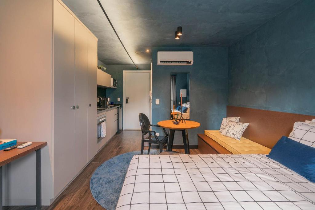 阿雷格里港Condomínio GO24的一间卧室配有一张床铺和一张桌子,还设有一间厨房