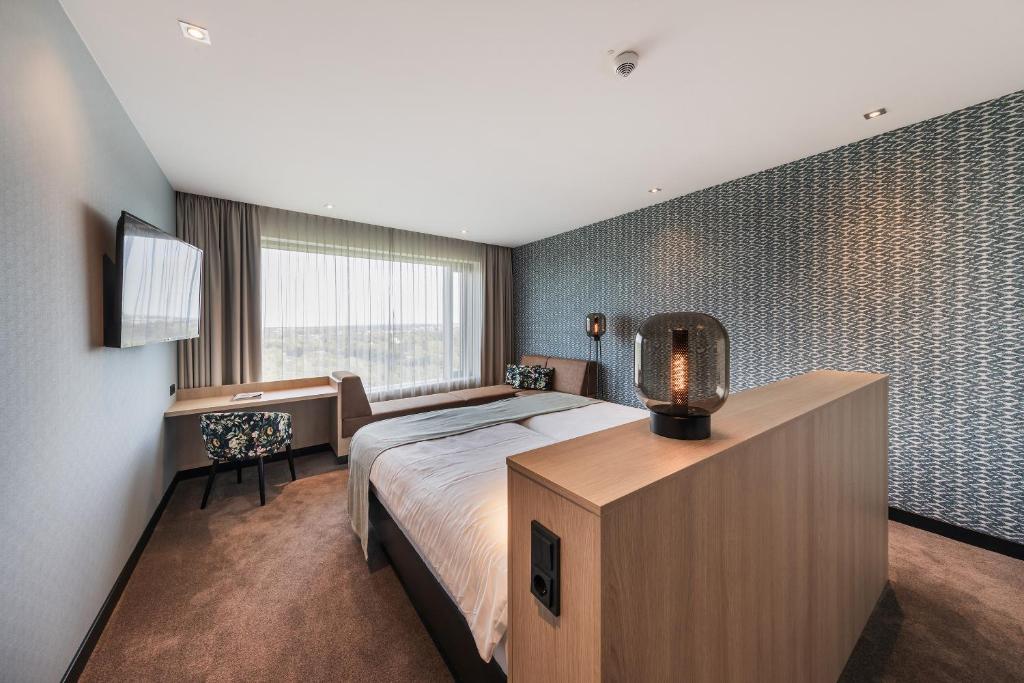 杜塞尔多夫杜塞尔多夫机场凡德瓦克酒店的一间卧室配有一张床、一张书桌和一个窗户。