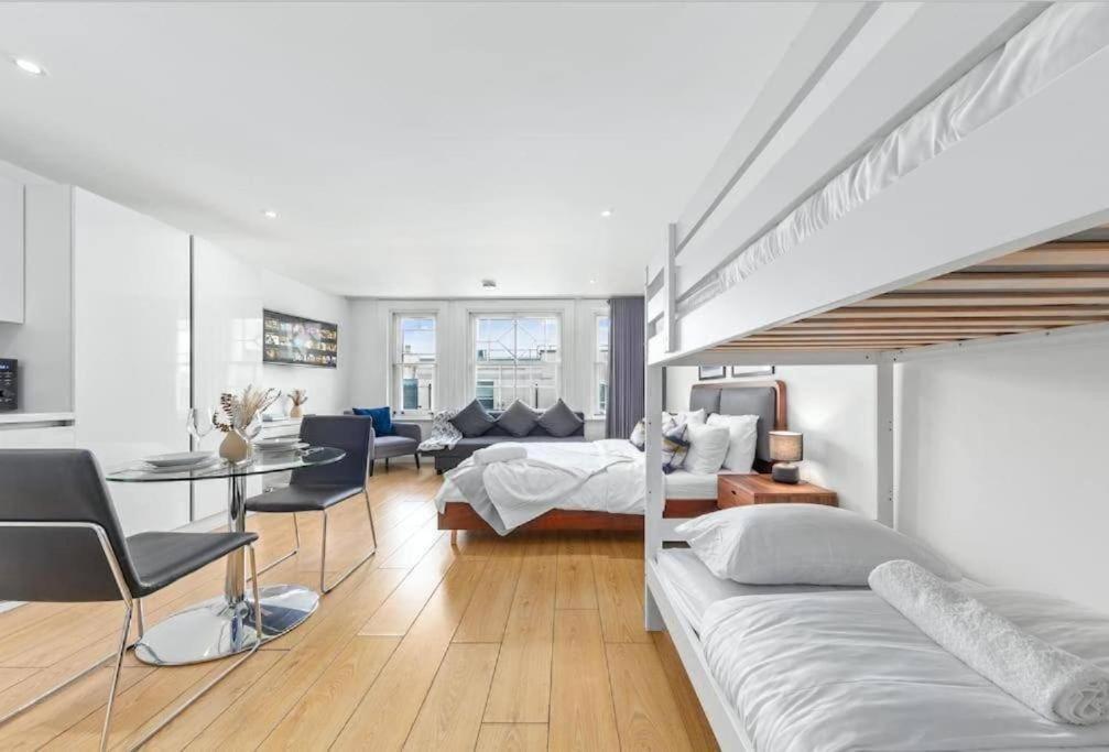 伦敦1 BR Flat Piccadilly Sleep 7 in London VR10的一间卧室设有一张床和一间客厅。