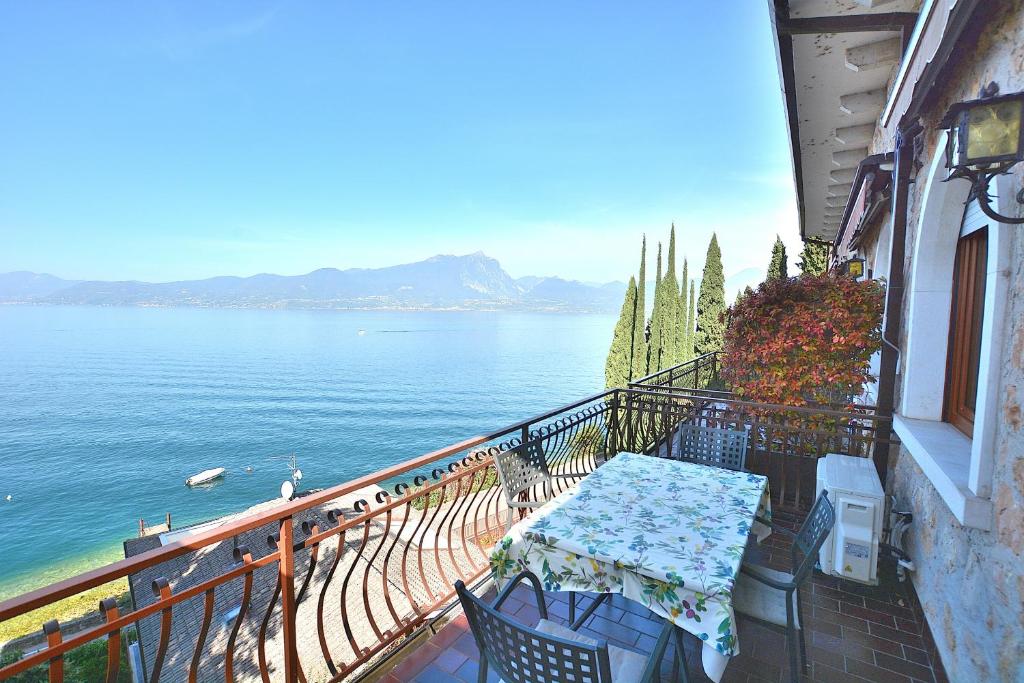 托里德尔贝纳科Leonardo Walsh Apartment With Lake View的俯瞰水面的阳台配有桌椅