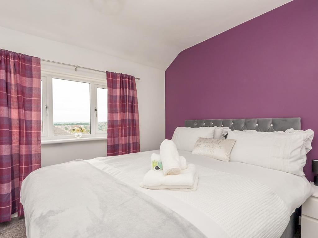 利兹Pass the Keys Large Family Getaway的卧室配有白色床、紫色墙壁和窗户