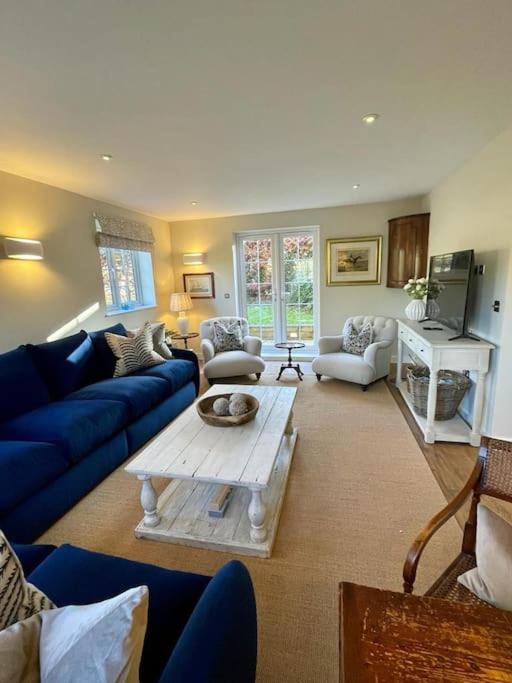 法纳姆Northbrook Cottage, Farnham, up to 8 adults的客厅配有蓝色的沙发和咖啡桌